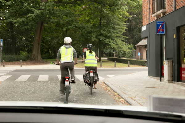 2 speedpedelecs naast elkaar in een fietszone, auto die erachter blijft rijden
