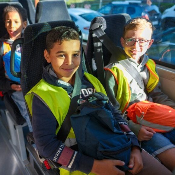 Kinderen in schoolbus die autogordel dragen