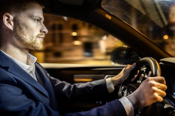 man geconcentreerd aan het autorijden