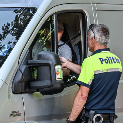 politie die alcoholcontrole afneemt bij bestuurder bestelwagen