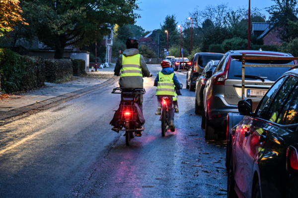 ouder met kind fietsen in het donker