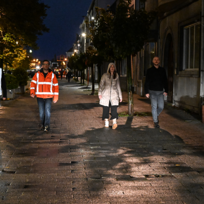 Personen met fluo, reflecterende en donkere kledij in het donker