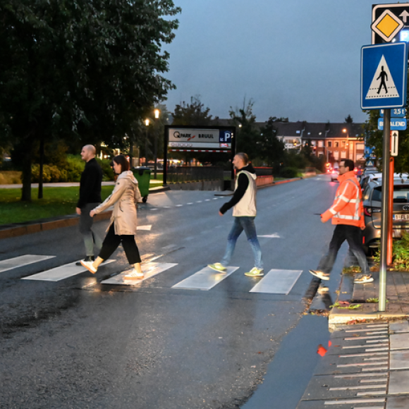 goed verlicht zebrapad in het donker met overstekende voetgangers