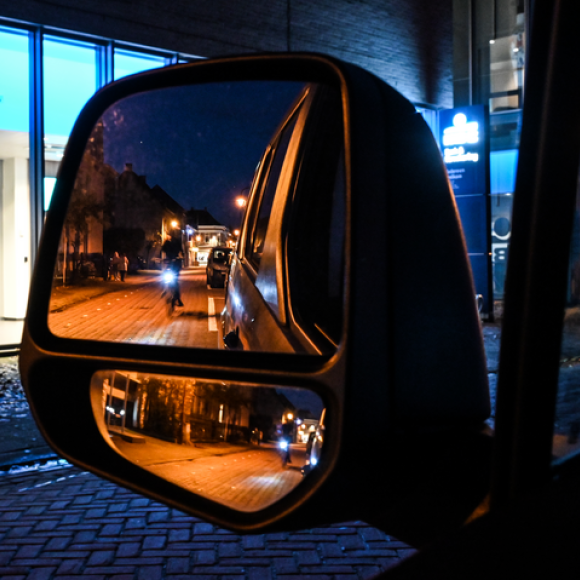 Fietsers in het donker zichtbaar in zijspiegel auto