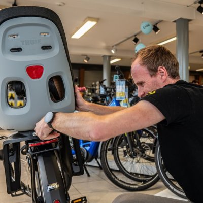 monteur die fietsstoel vastzet op fiets