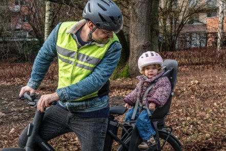 vader die fietst met kind in fietsstoeltje