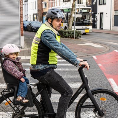 vader op fiets met fietsstoel aan een kruispunt