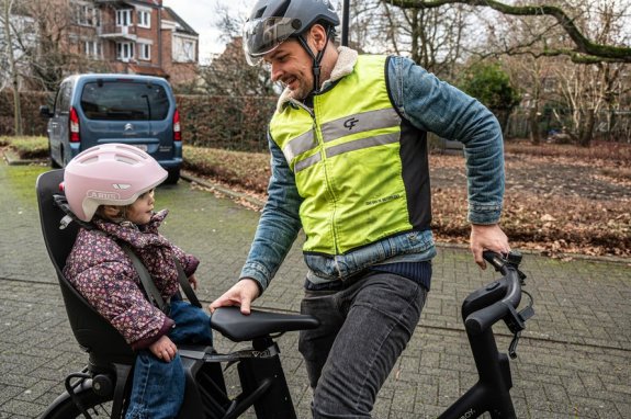 kind achterop een fiets in een fietsstoeltje