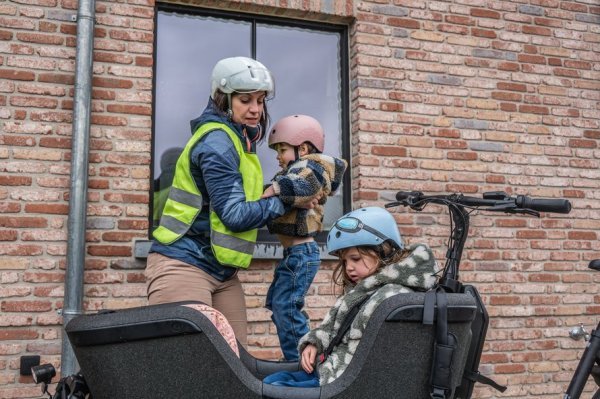 moeder die kind in de bakfiets zet