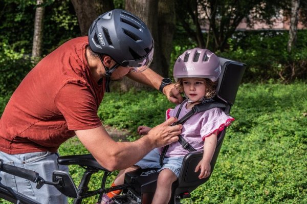 kader die gordels aandoet bij kind in een fietsstoel