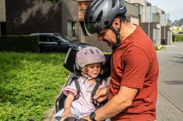 vader zet kind in fietsstoel