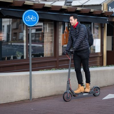 man op e-step op een fietspad