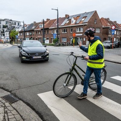 fietser steekt han op naar automobilist die voorrang geeft aan zebrapad
